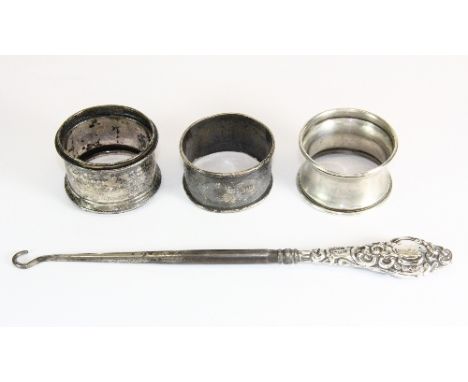 Three hallmarked silver napkin rings and silver handled button hook.