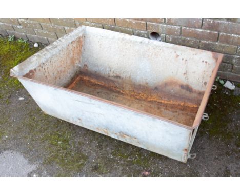 A GALVANISED METAL TROUGH of tapered rectangular section, 44cm high x 94cm long x 69cm wide
