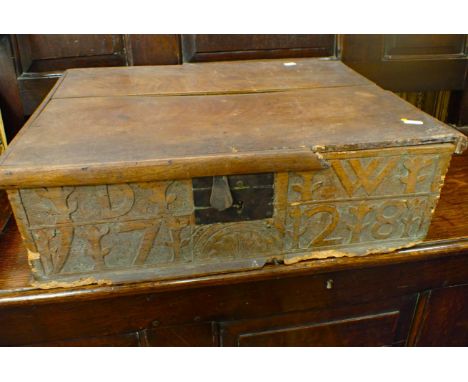 AN ELM BIBLE BOX, WITH CARVED INITIALS, DATED 1728 and lined with Victorian prints 58cm wide (woodworm damage)