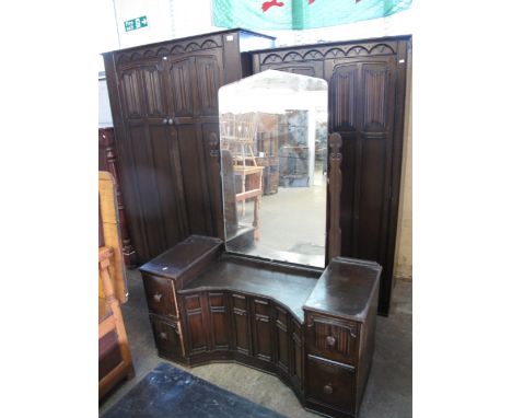 Mid 20th Century oak bedroom suite comprising two similar wardrobes and a mirror back dressing table. (3)