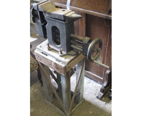 Large cast iron bench vice with anvil shaped top and wheel adjusted jaws.  Rustic wooden base.