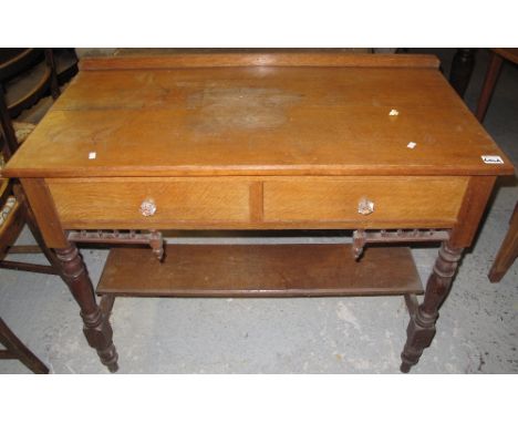 Late 19th Century oak two drawer side table or dressing table with under shelf on baluster turned legs.