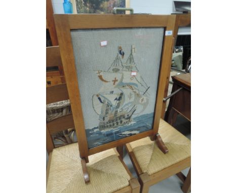 An art deco style fire screen having wool work inset depicting galleon