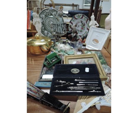 A selection of curios and trinkets including figures and geometry set