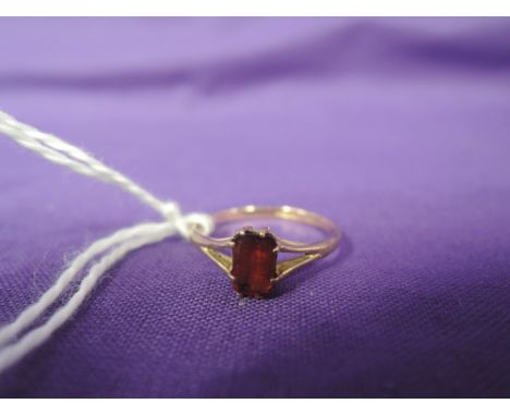 A lady's dress ring having a baguette cut fire opal style stone to open shoulders on a 9ct gold loop, size O