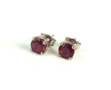 A pair of ruby earrings, each designed as a round mixed cut ruby stud weighing approx 1.25cts claw set in white metal with po