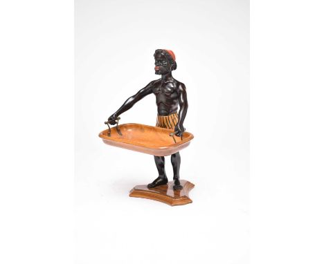 A 19th century Italian, blackamoor table card tray, standing, whilst holding a walnut tray, wearing striped pantaloons, raise