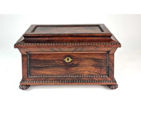 A Regency rosewood tea caddy, of sarcophagus form, with a beaded panel on the top and front and beaded edges, the interior wi