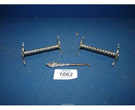 A small Silver handled glove button hook stamped Chester 1906, plus a pair of Gothic style metal knife rests with twisted ste