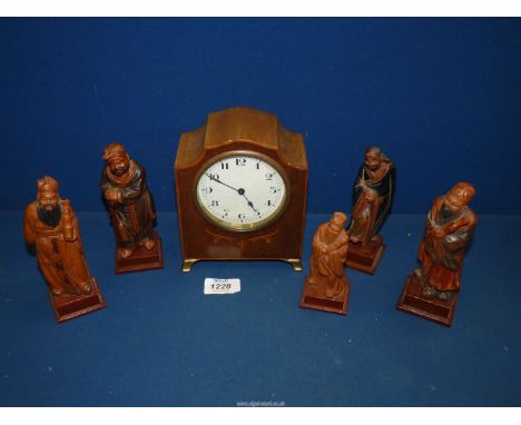 Five Chinese carved figures and an inlaid wooden cased Mantle clock on brass feet having Arabic numerals on white circular fa