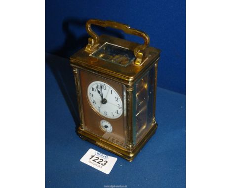 A French made Brass and bevelled glass cased Carriage Clock having an alarm movement, the white face (with hairline cracks) h