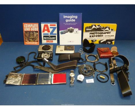 A box of various cameras and photographic accessories including a Metraphot light meter, an unbranded range finder, straps an
