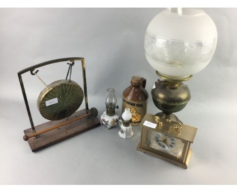 BRASS OIL LAMP, 48cm high, along with other objects, including a table gong and a mantel clock