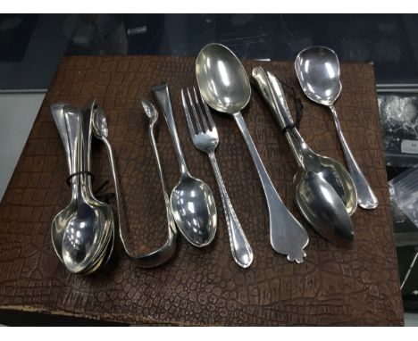 TWELVE VARIOUS SILVER SPOONS, including teaspoons, along with a pair of silver sugar tongs, silver cake fork and a sugar spoo