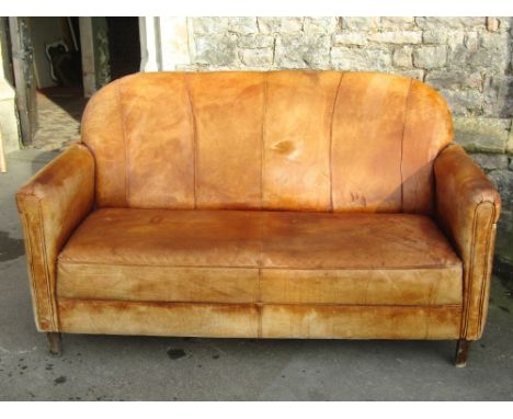 An Art Deco style stitched tan leather upholstered two seat sofa with piped detail and rounded arms raised on simple square t