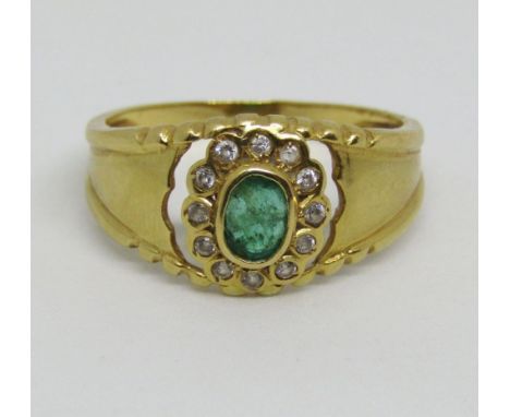 18ct floral cluster ring set centrally with an oval emerald within paste set surround, size P, 3.4g