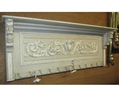 A Victorian carved oak wall mounted hat and coat rack, with scrolling acanthus, face mask and further applied moulded detail,