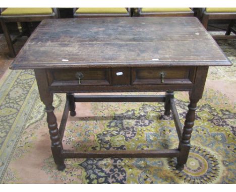 An early 18th century oak side table enclosing a single frieze drawer, presented as two short drawers, raised on four bobbin 