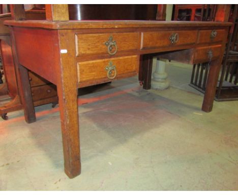 A Victorian gothic revival oak kneehole writing desk with faux inset leather panelled top over an arrangement of five frieze 