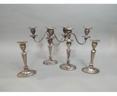A pair of 19th century silver plated twin branch candelabra, together with a matched pair of candlesticks (4)