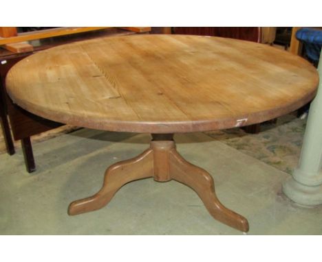 A stripped pine breakfast table of circular form raised on a turned pillar and shaped tripod to seat four to six, 138 cm in d