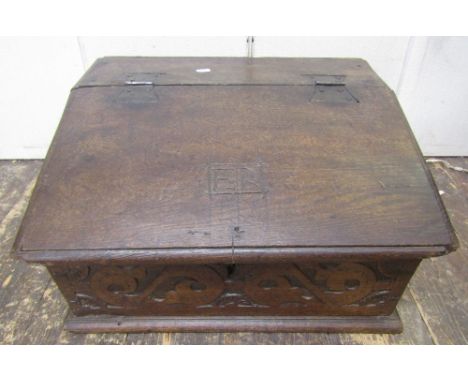 An 18th century oak writing slope, the front panel with repeating geometric detail, the rising lid with butterfly hinges, rev