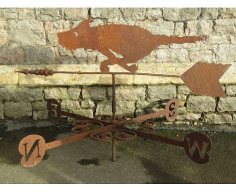 An iron work weather vane with simple scroll work detail, beneath a raised arrow pointer with sheet steel finial in the form 