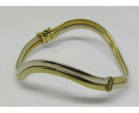 9ct bi-colour hinged bangle of wavy form, 12.3g