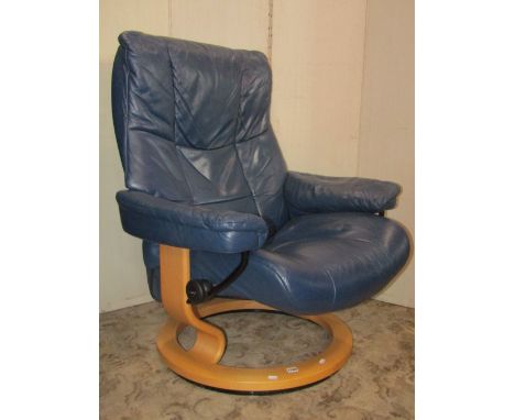 An Ekornes Stressless swivel and adjustable lounge chair with soft stitched navy blue leather upholstery, together with a mat