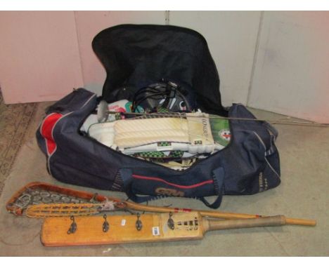 A Gunn and Moore sports bag and contents to include cricket pads, helmet and a bat later adapted as a coat rack, lacrosse rac