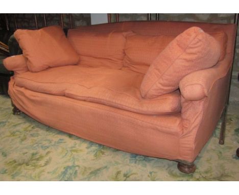 An Edwardian low deep seated two to three seat sofa with floral patterned upholstery and later loose cover, squab feather fil