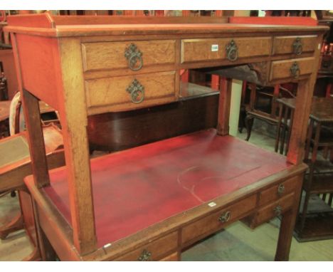 A Victorian gothic revival oak kneehole desk with shallow three quarter gallery over an arrangement of five frieze drawers wi