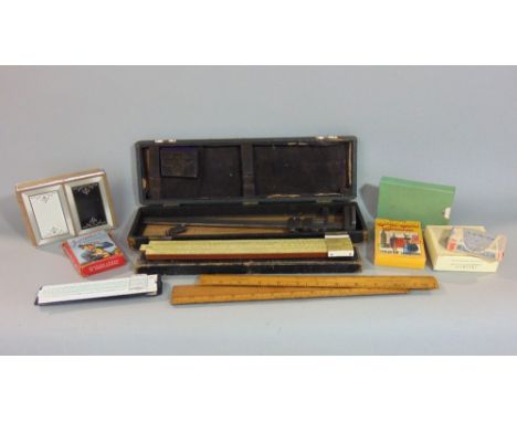 A box containing a collection of antique measuring tools and gauges together with various cards and games
