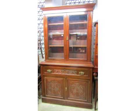 A late Victorian/Edwardian walnut secretaire bookcase, the upper recessed section enclosed by a pair of rectangular glazed pa