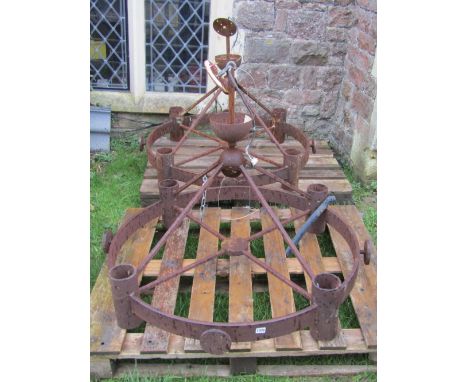A pair of heavy gauge ironwork hanging ceiling lights of hooped form, with four cylindrical turreted light fittings, the main