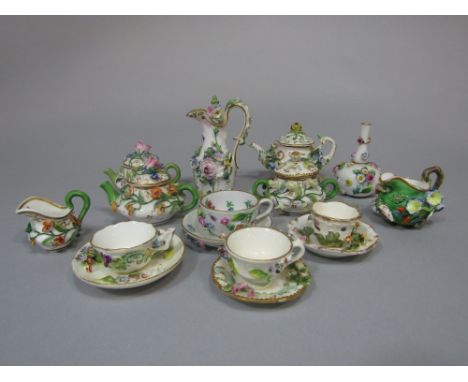 An interesting collection of 19th century floral encrusted miniature wares including continental examples, comprising a ewer 