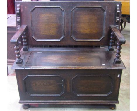 1920s Jacobean revival oak monks’ bench with geometric mouldings and carved detail, the sliding rectangular plank top raised 