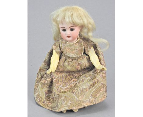 A small Kammer and Reinhardt bisque porcelain head doll, circa 1910, wearing blonde wig, with brown glass sleeping eyes, pain
