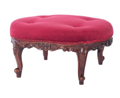 A carved walnut oval low stool in Victorian style, with stuff over button down upholstery to match the previous lots, having 