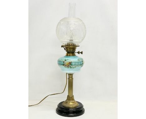 A large Victorian double burner electrified oil lamp with hand painted glass bowl and brass column. 69cm 