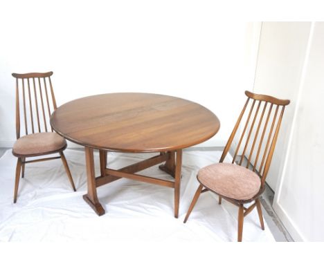 'ERCOL' ELM DINING TABLEwith shaped drop flaps and standing on shaped supports, together with four single and two carver Erco