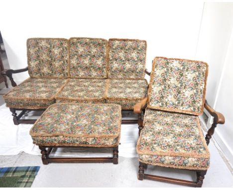 VINTAGE ELM FRAMED COTTAGE SUITEcomprising a three seater settee, with carved top rail and spindle back, with floral pattern 