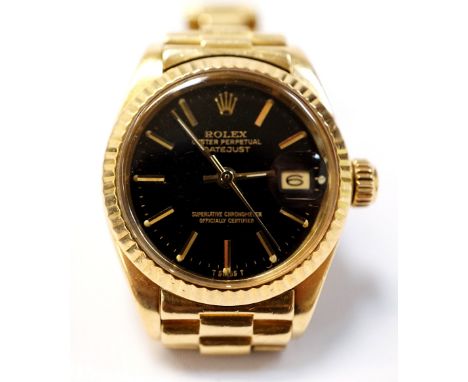 LADIES EIGHTEEN CARAT GOLD ROLEX OYSTER PERPETUAL DATEJUST WRISTWATCHthe black dial with baton markers and cyclops date apert