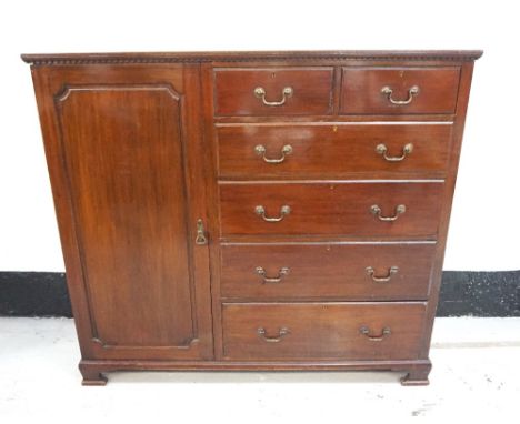 MAHOGANY COMPACTUMwith a moulded top and a dentil frieze above a panelled cupboard door flanked by two short and four long gr