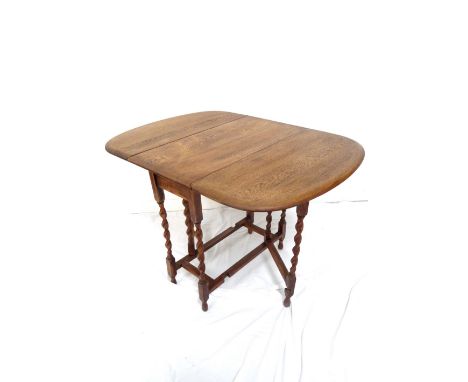 OAK GATE LEG DINING TABLEearly 20th century, with shaped drop flaps, standing on barley twist supports united by a stretcher,