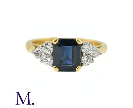 A Sapphire And Diamond Ring in 18k yellow gold, the central step cut sapphire of approximately 1.50cts flanked either side nu