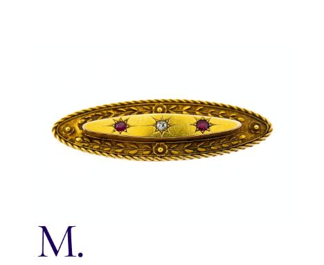 An Antique Ruby And diamond Brooch in 15k yellow gold, the elongated oval form set to the centre with an old cut diamond flan