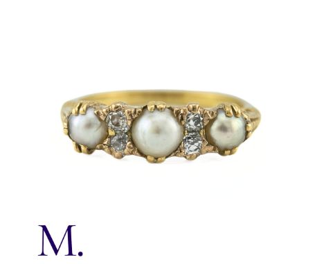 An Antique Pearl And Diamond Ring in 18k yellow gold, set with a row of three pearls punctuated by pairs of old cut diamonds.