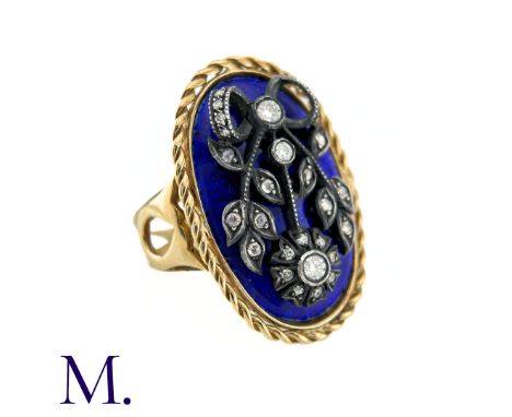 A Blue Enamel And Diamond Ring in yellow gold and silver, the central blue enamelled plaque adorned with foliate and bow moti