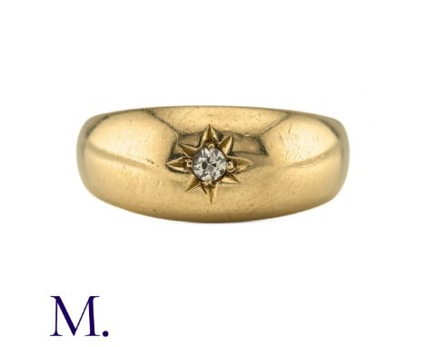 A Diamond Gypsy Ring in 18k yellow gold, the wide band set with a round cut diamond to an engraved star motif. Hallmarked for